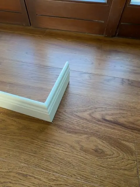 Pavimento effetto legno con battiscopa bianco appena posato